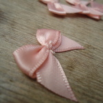 Salmon Pink satin ribbon bows, 15 in a pack, dressmaking supplies and online haberdashery, pretty ribbon bows for sale, trimmings and accesories for sewing online shop at HandBound Costume Supplies