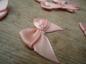 Salmon Pink satin ribbon bows, 15 in a pack, dressmaking supplies and online haberdashery, pretty ribbon bows for sale, trimmings and accesories for sewing online shop at HandBound Costume Supplies