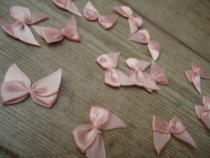 Salmon Pink satin ribbon bows, 15 in a pack, dressmaking supplies and online haberdashery, pretty ribbon bows for sale, trimmings and accesories for sewing online shop at HandBound Costume Supplies