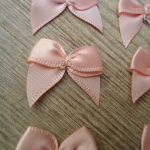 Salmon Pink satin ribbon bows, 15 in a pack, dressmaking supplies and online haberdashery, pretty ribbon bows for sale, trimmings and accesories for sewing online shop at HandBound Costume Supplies