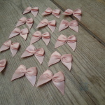 Salmon Pink satin ribbon bows, 15 in a pack, dressmaking supplies and online haberdashery, pretty ribbon bows for sale, trimmings and accesories for sewing online shop at HandBound Costume Supplies